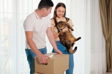 Karı koca yeni eve kutu ve sevimli kedi taşıyorlar.
