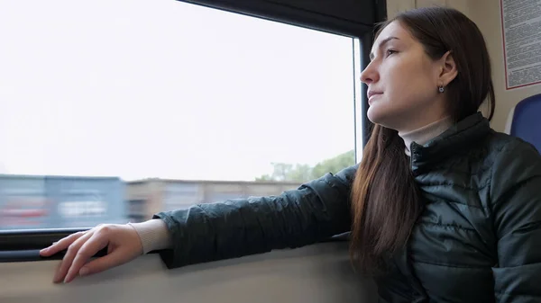 Vrouw in de trein. Ze zit en kijkt uit het raam. — Stockfoto