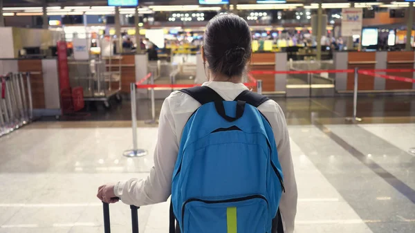 La donna sta andando al banco di registrazione nel terminal dell'aeroporto, vista posteriore . — Foto Stock