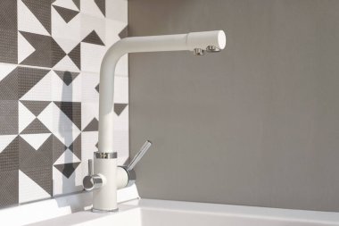 Mutfak açısında beyaz ve gümüş renkli su bandı