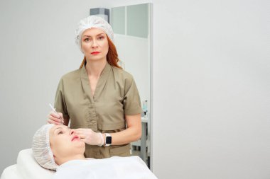 Doktor tıbbi tedavi için kolajenle şırınga kullanıyor.