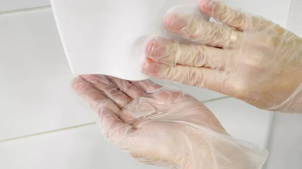 Vrouw hand duwt antiseptische dispenser om gel close-up te krijgen — Stockfoto