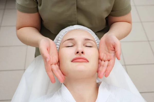 Massagista mãos mover fazendo calmante rosto massagem vista superior — Fotografia de Stock