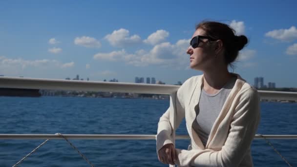 Menina senta-se no corrimão do convés do navio apreciando vela no mar — Vídeo de Stock