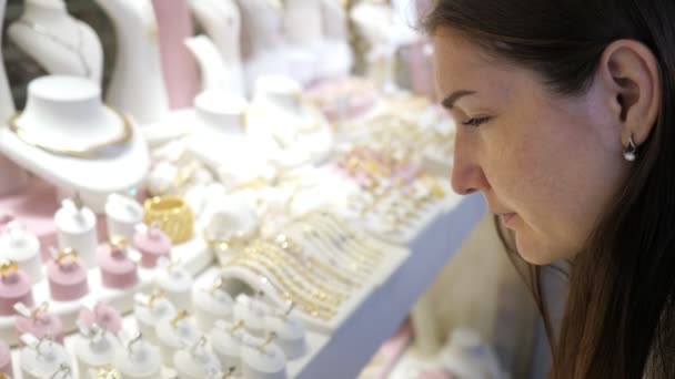 Chica mira joyas caras y hace la elección en la tienda — Vídeos de Stock