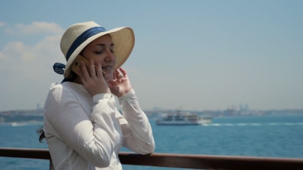 Lady travels by ship and talks on phone standing on deck — Stock Video