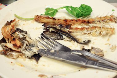 Tabakta yenmiş balıkların kalıntıları.