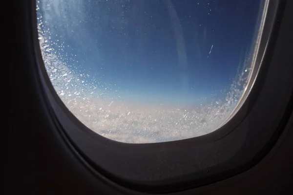 Zamrożone okno wewnątrz samolotu pokryte lodem podczas lotu, widok zbliżenie. — Zdjęcie stockowe