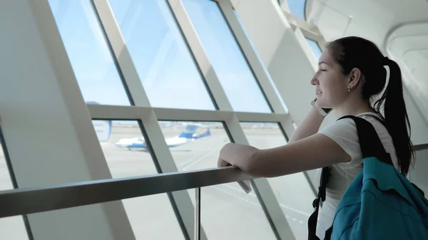 Молодая женщина разговаривает по мобильному телефону в терминале аэропорта в зоне полета . — стоковое фото