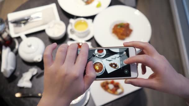 Mulher tira fotos de comida no telefone em um café — Vídeo de Stock