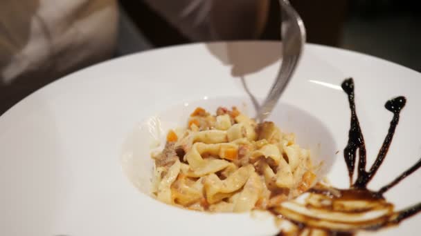 Close-up van pasta in een grote schaal. Vrouwen hand met vork — Stockvideo