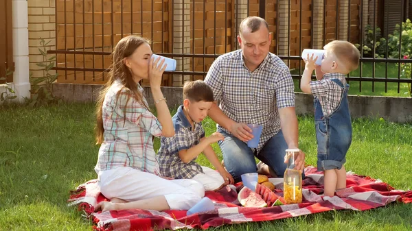 Niños pequeños felices disfrutan de picnic con la madre padre riendo — Foto de Stock