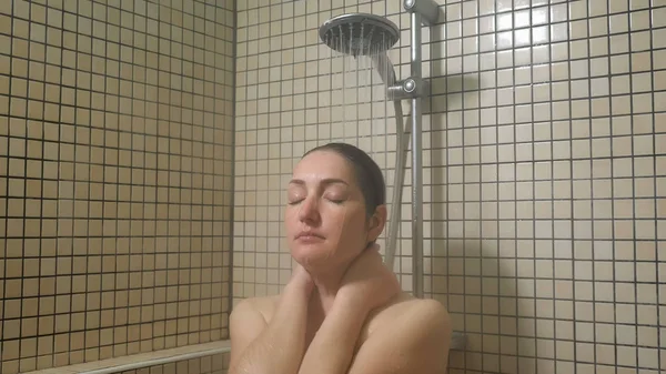 Portret młodej kobiety biorący ciepły prysznic cieszący się procesem z bliskimi oczami. — Zdjęcie stockowe