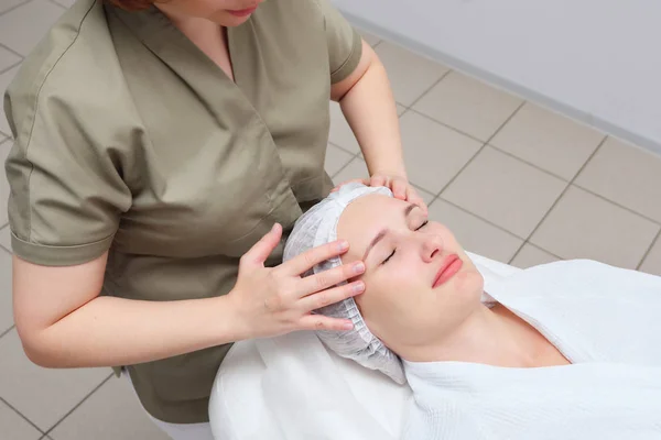 Massagista faz massagem facial para a mulher na clínica médica — Fotografia de Stock