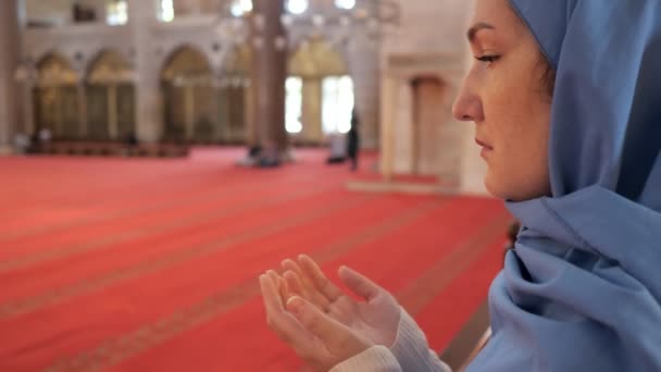 Woman prays holding hand palms up and standing in mosque — Stock Video