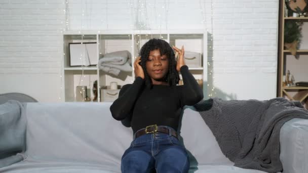 Modische schwarze Dame in Pullover-Jeans hört Musik — Stockvideo