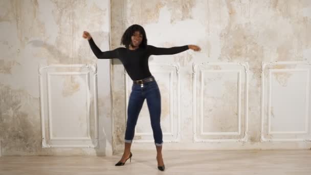 Schwarze Frau in Jeans und Pullover tanzt in High Heels — Stockvideo