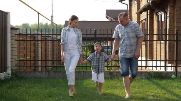 Far och vacker mor hålla lycklig liten pojke händer — Stockvideo