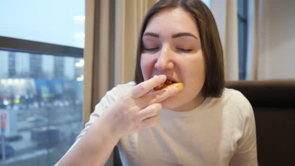 Mujer joven comiendo bruschetta con queso y tomates — Vídeos de Stock