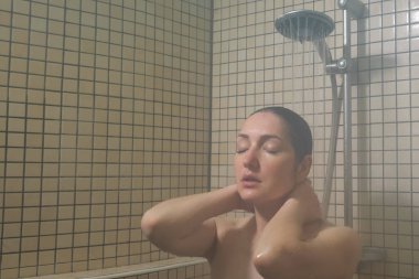 Uzun saçlı esmer kadın duş alıyor