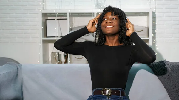 Moda negro dama en jersey jeans escucha música —  Fotos de Stock