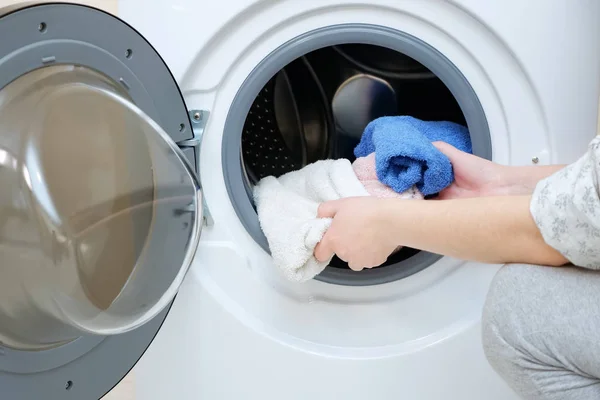Frau lädt schmutzige Handtücher in Waschmaschine — Stockfoto