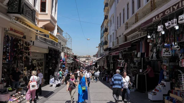 İstanbul caddesinde turistler ve yerel halk mağazaların önünden geçiyor