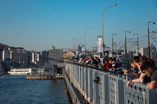Рыбаки на переполненном мосту Галата с ресторанами на нижней палубе в Стамбуле — стоковое фото