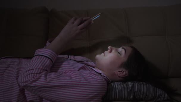 Mladá žena se převrátí přes sociální média krmení na svém telefonu — Stock video