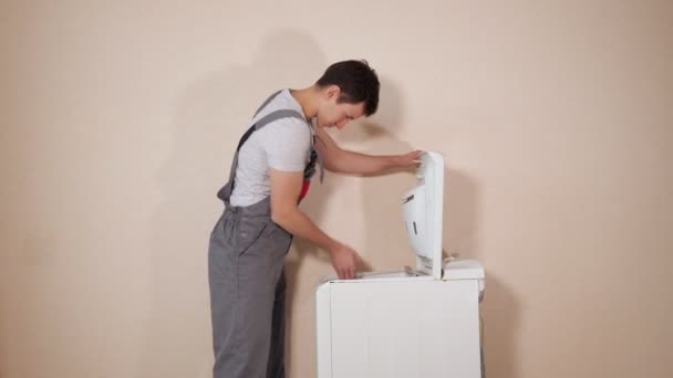 Worker opens broken top loader washing machine near wall — Stock Video