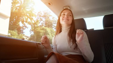 Kadın limuzinde oturur ve dans eder. Gezmekten zevk alır.