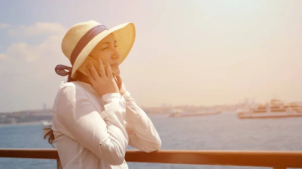 Леди путешествует на корабле и разговаривает по телефону стоя на палубе — стоковое фото