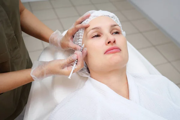 Médico-cosmetician injeta a medicina gel-como abaixo da pele — Fotografia de Stock