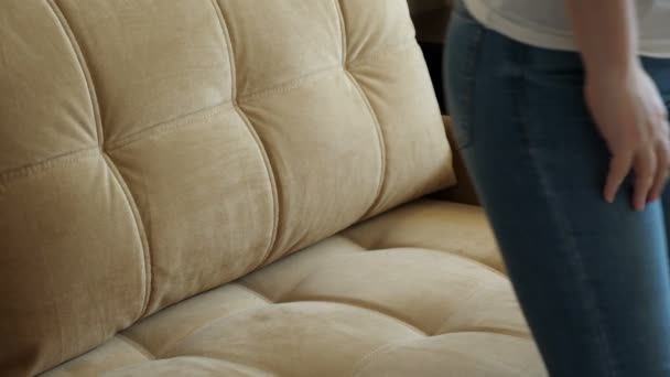 Setzt sich die Frau auf das Sofa und zieht ihre enge Jeans aus. Übergewicht — Stockvideo