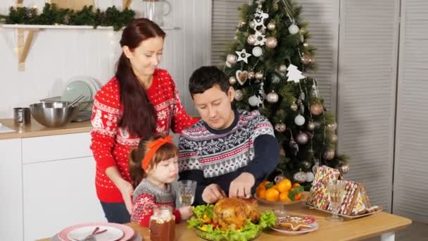 Vrouw kussen eten dochter zitten door vader in keuken — Stockvideo