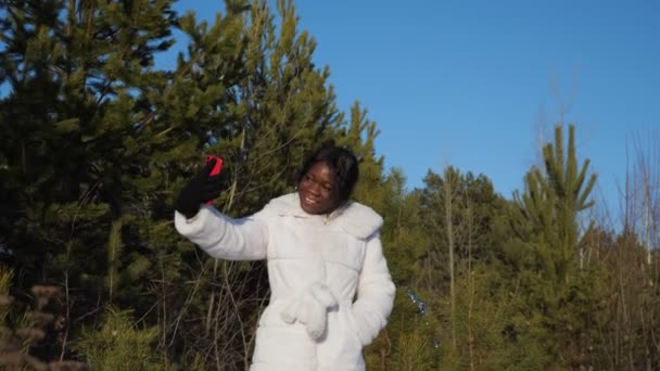 Negro mujer hace selfie en invierno bosque bajo claro cielo — Vídeos de Stock