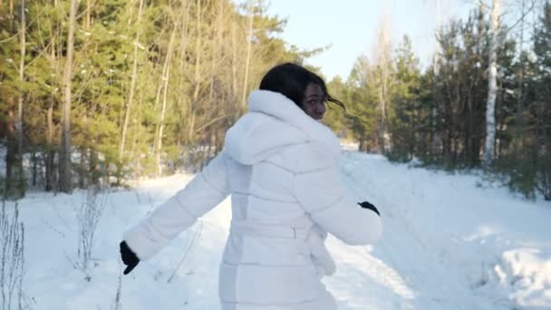 Mujer de piel oscura corre a lo largo del camino del bosque mirando hacia atrás — Vídeo de stock