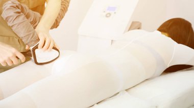 Terapist hasta üzerinde lipomasaj mekanik aygıtı taşıyor