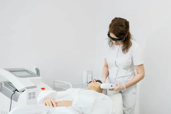 Terapeuta qualificado faz remoção de cabelo a laser no rosto do paciente — Fotografia de Stock