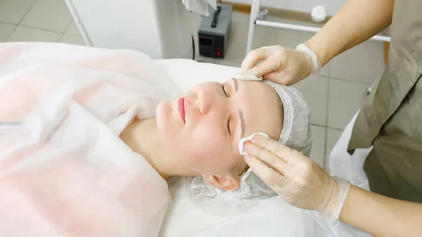 Therapist in white sterile gloves rinses patient face close — Stock Photo, Image