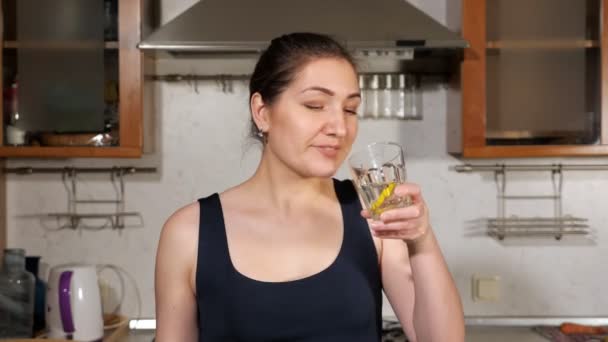 Chica sonriente bebe agua con limón — Vídeo de stock