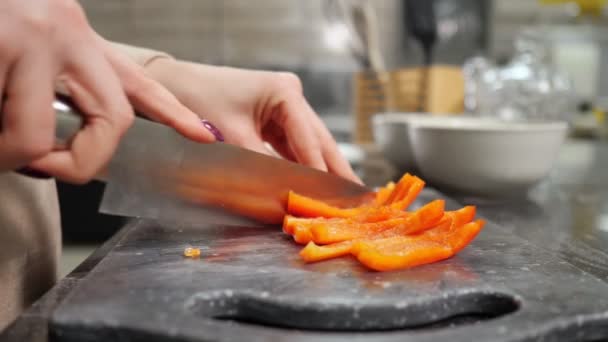 Домогосподарка вирізає перець на обробній дошці, роблячи салат — стокове відео