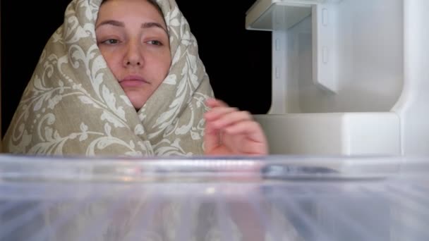 Chica abre refrigerador y toma barra de chocolate y manzana — Vídeos de Stock