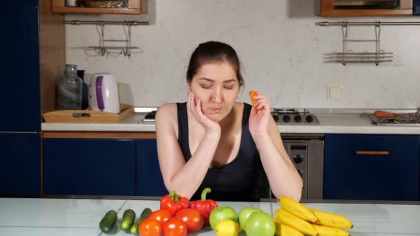 女の子ブロガーは野菜と一緒にテーブルに座ってレタスを食べる — ストック動画