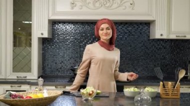 Müslüman kadın yemek pişirdikten sonra oryantal dans eder.