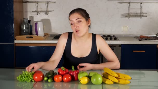 Girl blogger eats lettuce sitting at table with vegetables — Stock Video