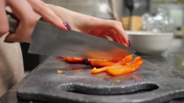 Домохозяйка режет перец на доске, делая салат — стоковое видео