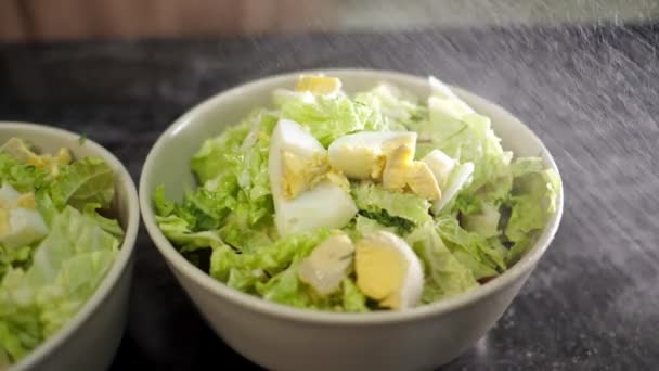 Pessoa temperos salada fresca em tigelas com temperos perfumados — Vídeo de Stock