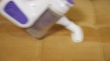 Kanepenin üzerindeki elektrik süpürgesinin yakın çekimi. Ev temizliği