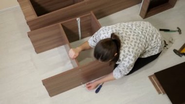 Kadın oturur ve yeni mobilya döner enstrüman monte eder